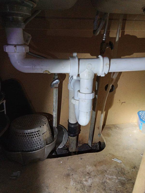 Conducted comprehensive plumbing assessment of residential property built in 1910 to provide repiping estimate. Evaluated existing bathroom fixtures including vintage toilet with ceramic tank, fiberglass bathtub, and aging supply lines showing signs of deterioration. Inspected kitchen cabinet plumbing system featuring white PVC drain assembly with P-trap configuration and metal supply lines. Documented condition of all visible plumbing infrastructure, noting wear patterns, potential corrosion on support structures, and water staining in cabinet areas. Provided detailed estimate for complete bathroom renovation and whole-house repiping project to address aging galvanized or original piping systems typical of early 20th century construction.