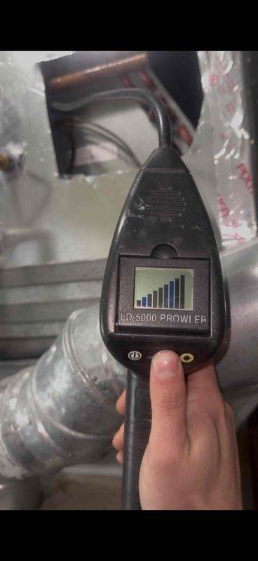 Responded to follow-up service call for 11-year-old air conditioning system with evaporator coil located in basement. Previous technician had identified refrigerant loss requiring leak detection and repair. Utilized LD 5000 Prowler electronic leak detector to perform comprehensive leak search on refrigeration circuit. Located active refrigerant leak at copper tubing connection point near evaporator coil assembly. Copper lines showed significant oxidation and age-related deterioration consistent with system age. Repaired leak at defective fitting connection, pressure tested system to verify repair integrity, evacuated system to remove moisture and non-condensables, and recharged unit to manufacturer specifications. Verified proper system operation and refrigerant charge upon completion.