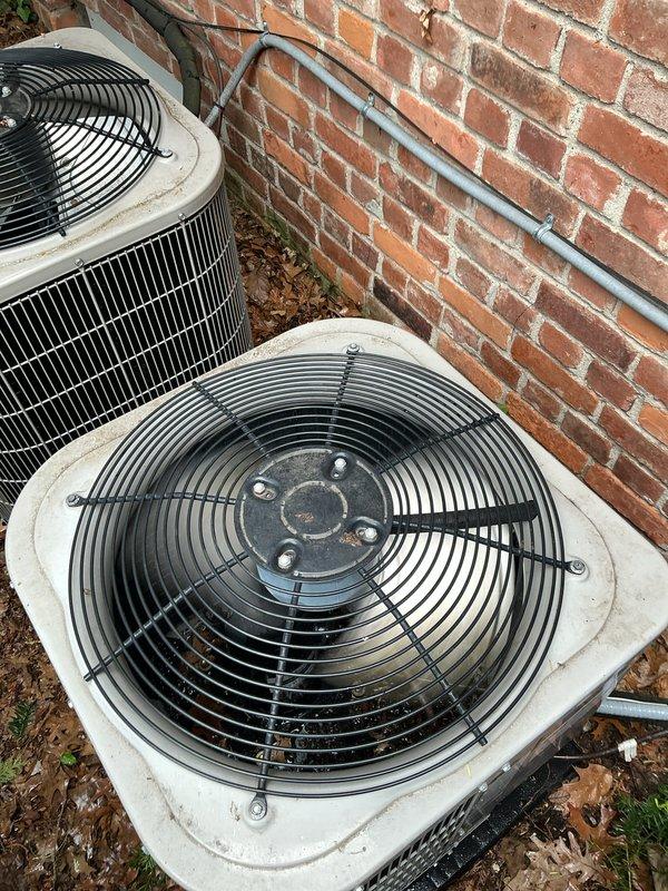 Completed Gold AC Inspection on single-unit residential HVAC system with 2015 equipment. Performed comprehensive maintenance evaluation of two outdoor condenser units located at ground level against building exterior and air handler/coil assembly located in basement. Inspected fan assemblies, protective grilles, and motor hubs on both condenser units, noting normal wear consistent with age and outdoor exposure. Verified operational status of equipment, confirmed proper electrical connections and conduit mounting, and assessed overall system condition. All components functioning as designed with weathering appropriate for unit age.