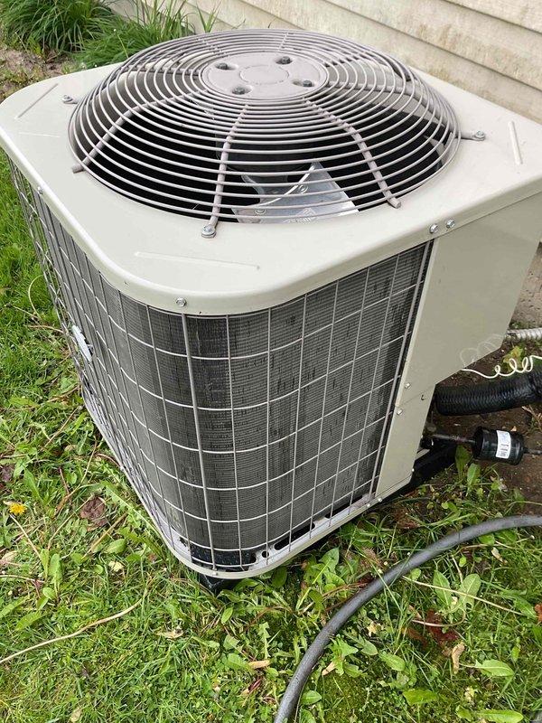 Completed Gold AC inspection on a single 2021 outdoor condensing unit with air handler located in basement. Unit operational at time of inspection. Observed moderate debris accumulation on condenser coil fins, particularly in upper sections, with environmental dust and lint buildup noted during visual assessment. Exterior cabinet and protective wire grilles in good condition with no visible damage to housing or components. Homeowner advised that uninterruptible service option was affected by recent DTE furnace installation and expressed interest in exploring restoration options for this service feature.