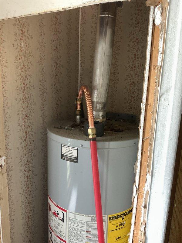 Conducted on-site evaluation of existing gas water heater to assess code compliance and provide estimate for potential conversion to electric unit. Inspected current installation located in interior closet space, noting deteriorated surrounding conditions and aging infrastructure. Evaluated existing gas supply line configuration, venting system, and available electrical capacity to determine feasibility of converting from gas to electric water heater. Assessed clearance requirements, accessibility, and structural considerations for new electric unit installation. Documented current water heater specifications and installation conditions through photographic evidence. Provided homeowner with professional assessment regarding code compliance issues and outlined scope of work required for electric conversion, including new dedicated electrical circuit installation, removal of existing gas lines, and proper venting modifications.