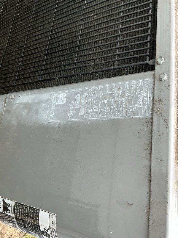 Completed comprehensive Gold AC Inspection and annual maintenance on residential air conditioning system located in backyard. Performed thorough visual inspection of outdoor condensing unit, including examination of electrical disconnect box, condenser coils, and exterior cabinet. Inspected electrical disconnect switch for proper operation and verified safety labeling present. Assessed condenser coil condition, noting normal weathering and environmental debris accumulation consistent with outdoor exposure. Examined unit cabinet panels and manufacturer data plate. Documented equipment condition through photographic records showing electrical disconnect box with visible weathering, functional ON/OFF toggle mechanism, and condenser coil assembly with heat exchanger fins in serviceable condition. Unit found to be operational with normal wear patterns expected for outdoor HVAC equipment. All safety components verified functional and properly labeled.