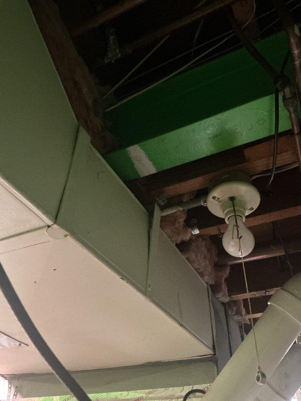 Completed comprehensive Gold AC inspection on 5-year-old residential air conditioning system with air handler and coil located in basement. System was operational upon arrival with homeowner present. Performed full visual inspection of indoor air handling equipment, including examination of copper refrigerant lines, condensate drainage system, and electrical connections. Inspected evaporator coil assembly and surrounding ductwork infrastructure within basement mechanical space. Verified proper insulation coverage on refrigerant lines and noted existing repair material on copper piping joints. Evaluated structural mounting and support of air handler components. Documented equipment condition through photographic records showing basement installation area, exposed ceiling joists, copper line sets, and insulation materials. All system components found operating within normal parameters at time of inspection.