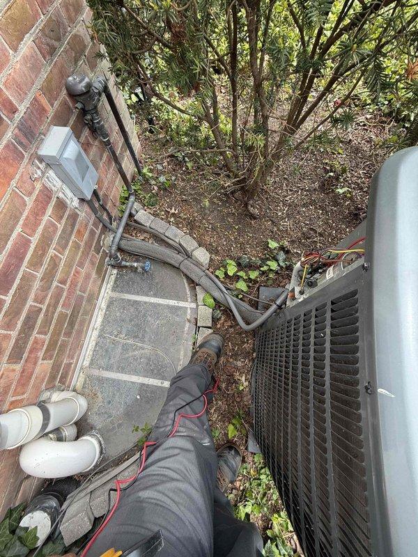 Completed comprehensive Gold AC inspection on 10-year-old Goodman air conditioning system. Performed thorough evaluation of outdoor condensing unit, confirming proper operation and assessing overall system condition. Inspected condenser cabinet, louvered fins, and external components for signs of wear, damage, or deterioration. Verified electrical connections and refrigerant lines running from building to condensing unit. Examined air handler/coil assembly located in basement. Assessed installation area, noting adequate clearance around outdoor unit and proper drainage line configuration. Confirmed system is functioning as designed with no immediate service needs identified. All components inspected and found to be in satisfactory operating condition for equipment age.