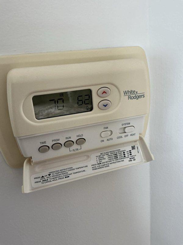 Completed comprehensive Gold AC inspection on 1-year-old Bryant HVAC system with air handler located in basement. Verified proper thermostat operation on White-Rodgers programmable unit displaying appropriate temperature readings and functional control settings. Inspected furnace unit, ductwork connections, and associated components with all equipment confirmed operational and in good working condition. System passed inspection with no deficiencies noted.