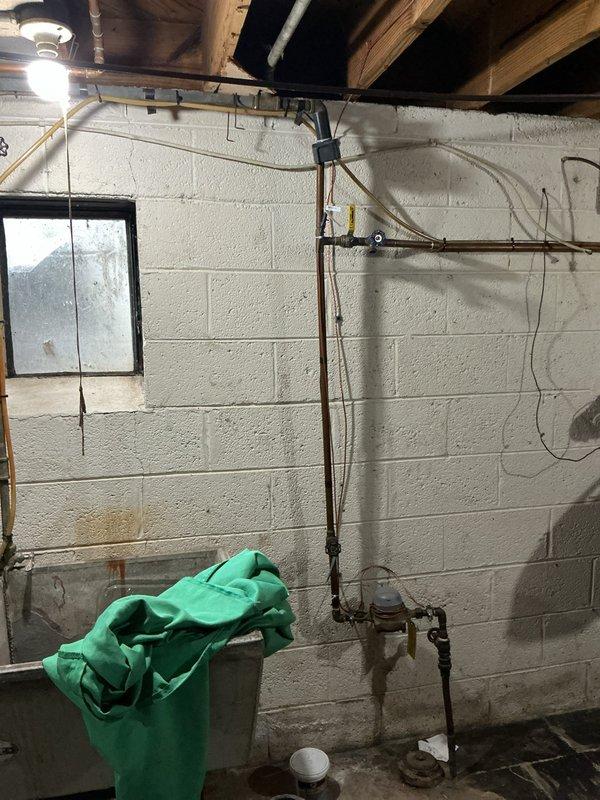 Responded to customer inquiry regarding backflow prevention testing and sprinkler system options. Upon inspection of the basement plumbing infrastructure, evaluated the existing copper piping system and backflow prevention assembly with blue-handled valve. Assessed the sprinkler system connection points and discussed options with homeowner for either annual backflow testing certification or permanent cap-off of the irrigation system to eliminate future testing requirements.