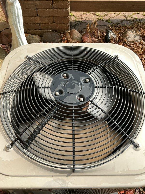 Completed scheduled maintenance inspection on 14-year-old air conditioning system with basement evaporator coil. Performed visual assessment of outdoor condenser unit, noting weathered housing with dirt accumulation and aged refrigerant lines showing significant corrosion on bare copper piping and staining on insulation wrap. System operational at time of inspection with fan assembly and protective grille intact.