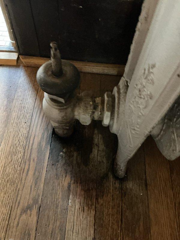 Performed diagnostic inspection on 10+ year old steam boiler system located in basement. Identified multiple issues requiring repair: two steam vents actively leaking during operation, sight glass assembly requiring replacement including gaskets and nuts with valves needing replacement due to missing handle, and angled radiator valve exhibiting active leak. Documented equipment condition with photos showing vintage cast iron radiator with worn valve assembly and aging infrastructure. Provided comprehensive quote for all necessary repairs to restore proper system operation and eliminate steam leaks.