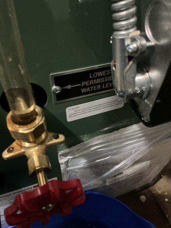Responded to callback for recently installed steam boiler reported to be leaking. Upon arrival, performed thorough visual inspection of boiler unit, sight glass assembly, brass valve connections, and all associated piping and fittings. Examined sight tube with brass fittings and red valve mounting bracket for signs of moisture or active leaks. Inspected all connection points on the green boiler casing, including the low water cutoff area and valve assembly extensions. Checked flexible corrugated piping and metal ductwork connections for proper sealing. Documented boiler condition with photographs showing sight glass, valve assembly, mounting hardware, and surrounding components. No active leaking observed during inspection period. All brass fittings, valve connections, and sight glass assembly appeared secure and properly installed. System pressure and water level within normal operating parameters at time of service call.
