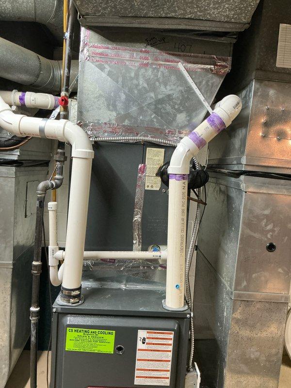 Provided comprehensive estimate for HVAC system replacement at residential property with 18-year-old equipment. One air conditioning unit currently non-operational while second unit remains functional. Assessment revealed significant frost and ice buildup on evaporator coil assembly located in basement, indicating potential refrigerant leak, restricted airflow, or system failure. Existing natural gas furnace with coil assembly, PVC condensate drainage system, copper refrigerant lines, and metallic ductwork evaluated for replacement options. Documented current installation configuration including air handler, evaporator coil with extensive frost accumulation, and associated mechanical components for equipment sizing and replacement specifications.