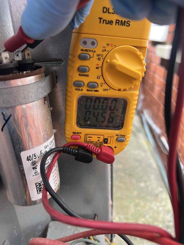 Completed comprehensive tune-up on 17-year-old HVAC system located in utility area. Performed full inspection including thermostat calibration, humidifier check, and hot water tank evaluation. Tested and verified run capacitor (40/5 µF) using digital multimeter to ensure proper electrical performance and system efficiency. Customer renewed maintenance plan onsite following inspection. Documented all findings with photos for service records.