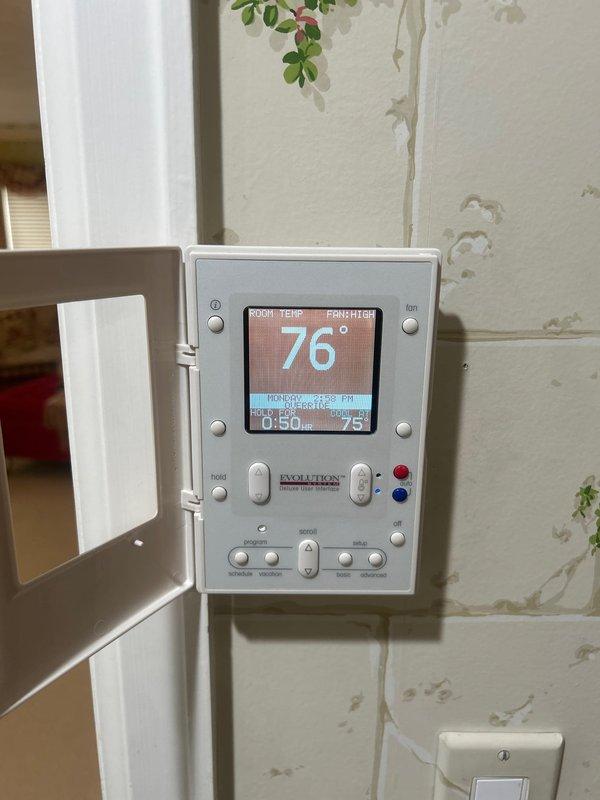 Completed air conditioning system startup for dual outdoor condenser units located in basement zone. Performed comprehensive system commissioning including electrical verification at disconnect boxes, refrigerant charge confirmation, airflow testing, and operational checks on both units. Verified Evolution thermostat programming and confirmed proper communication between indoor and outdoor equipment, with system maintaining setpoint at 76°F in AUTO fan mode.