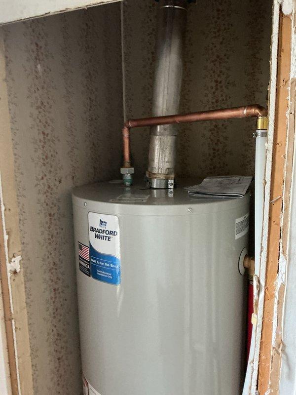 Completed installation of a 40-gallon Bradford White tanked water heater with full reconnection of copper supply lines and brass fittings, including proper venting through metallic flue pipe. Additionally performed miscellaneous plumbing tasks including toilet removal and valve replacement to support the overall mechanical system upgrade.