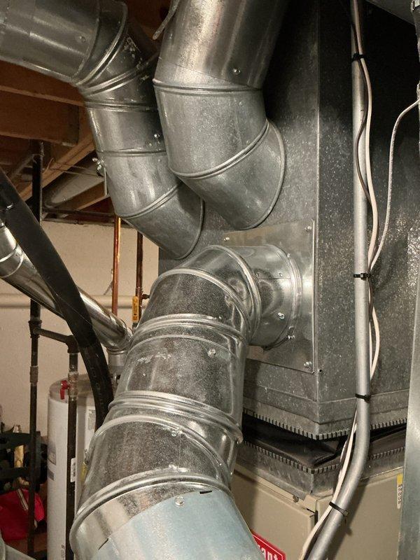 Provided estimate for complete air conditioning system replacement including evaporator coil located in basement. Existing 10+ year old unit is non-operational. Assessment included inspection of current natural gas furnace installation, basement-mounted evaporator coil, and existing ductwork distribution system throughout the property to determine compatibility and requirements for new equipment installation.