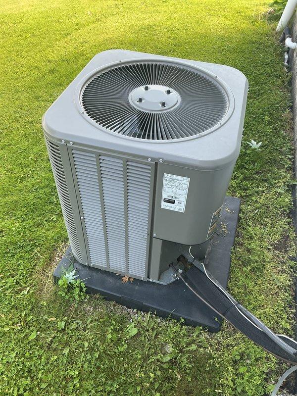 Completed annual Gold Plan maintenance inspection on 3-year-old residential air conditioning system with air handler located in attic and outdoor condenser unit. Performed comprehensive tune-up including visual inspection of both indoor and outdoor components, verified proper airflow through condenser louvers and fan operation, checked refrigerant lines and electrical conduit connections for integrity, and confirmed unit is operating within manufacturer specifications. Condenser unit found in excellent condition with no signs of damage, deterioration, or debris accumulation; pad placement and lawn clearance adequate for proper ventilation and drainage.