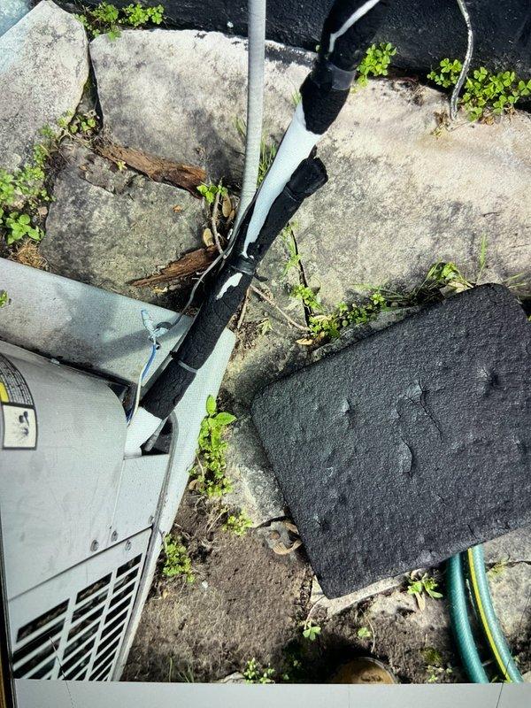 Responded to service call for central air conditioning system running continuously but failing to maintain desired temperature. Upon arrival, found thermostat set to 69°F with house temperature at 75°F. System was operational and producing cool air but with insufficient cooling capacity.

Performed comprehensive diagnostic evaluation of the split system. Inspected outdoor condensing unit located on exterior concrete pad. Noted unit showed signs of age and environmental exposure, with vegetation growth around base potentially restricting airflow. Examined refrigerant line set running from outdoor unit to indoor air handler, including insulated suction and liquid lines along exterior wall penetration.

Accessed attic space and inspected indoor evaporator coil assembly and refrigerant line connections. Documented condition of existing pipe insulation, including AEROCEL-wrapped suction line and foam insulation on copper refrigerant piping. Checked for proper insulation integrity and signs 