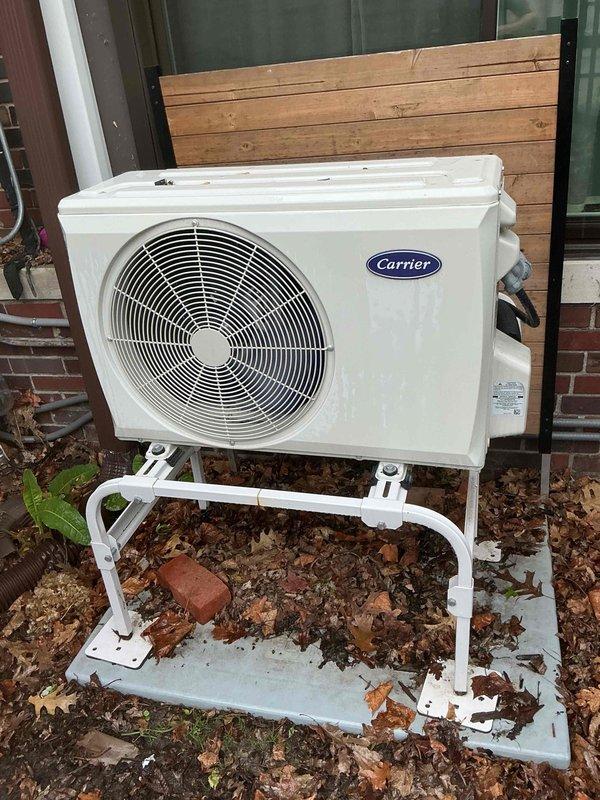 Completed comprehensive Gold AC inspection on residential property with two mini-split systems: a 1-2 year old unit serving the three-season room and a 3-4 year old unit located in the attic. Performed thorough visual inspection of outdoor Carrier condensing unit, verified proper operation of fan assembly, examined refrigerant line connections, and confirmed unit stability on concrete pad. Inspected condenser coil fins for debris accumulation and airflow restrictions, checked electrical connections at outdoor unit, and documented equipment condition through photographic documentation. Both systems were evaluated for proper operation within manufacturer specifications, with weather conditions suitable for accurate performance assessment.