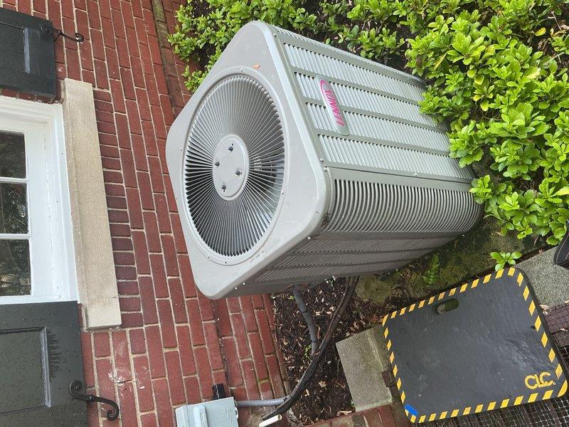 Completed comprehensive Gold AC inspection on 2015 Carrier system with air handler located in attic space and condenser unit mounted on exterior brick wall. Verified operational status of both indoor and outdoor components, inspected flex ductwork connections, examined condenser coils and fan assembly, and documented system condition through photographic evidence. All equipment found to be functioning properly with no immediate service needs identified.