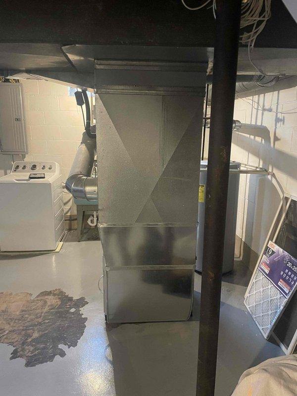 Conducted on-site evaluation for air conditioning system replacement estimate. Assessed existing 40-year-old outdoor AC unit located in backyard, inspected indoor air handler and ductwork system in basement utility area, and documented current HVAC configuration including metal ductwork connections, refrigerant lines, and electrical components to provide comprehensive replacement quote for aging system.