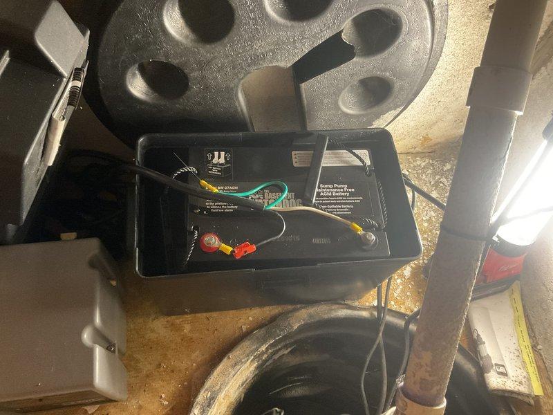 Serviced Pro Series 1/3 HP sump pump system experiencing indicator light issues with red and green lights activating. Inspected pump housing, control unit, and electrical connections in basement utility area. Examined wiring bundle containing multiple colored conductors within pump basin housing. Verified proper operation of float switch mechanism and checked control box functionality. Assessed discharge piping system including copper lines with insulation. Tested pump motor operation and confirmed system cycling properly after service intervention.
