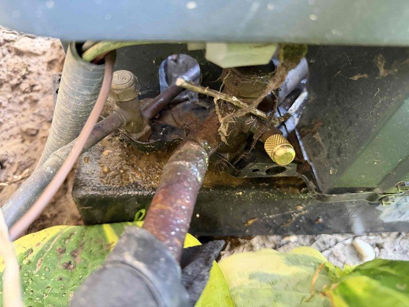 Responded to no-cooling complaint on 7-year-old Goodman air conditioning system. Upon arrival, performed diagnostic inspection of outdoor condensing unit and indoor air handler. Outdoor unit showed signs of environmental exposure with oxidized copper refrigerant lines and accumulated debris around service valves. Conducted system evaluation including electrical connections, refrigerant pressures, and operational testing. Documented equipment condition with photos showing outdoor unit components and indoor furnace installation. System assessed and customer advised of findings.
