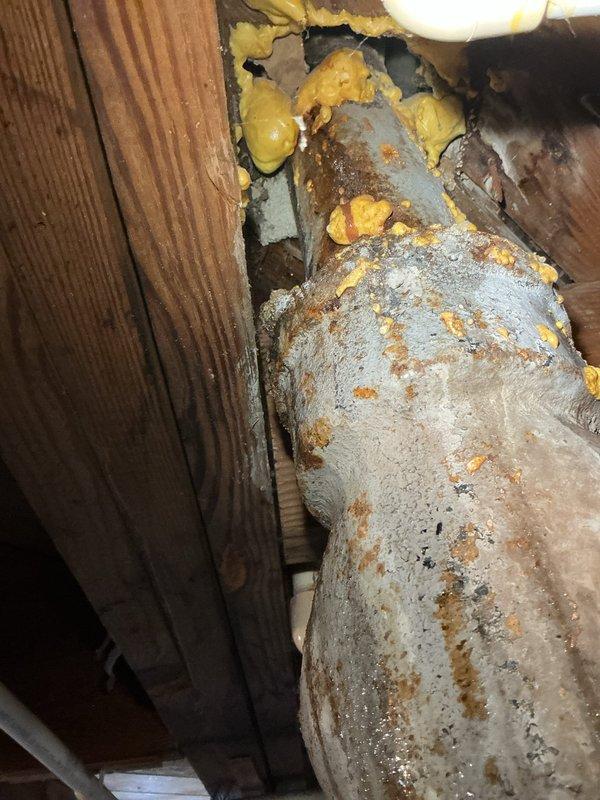 Responded to water leak originating from basement plumbing connected to toilet in 75-year-old residence. Located source of leak at pipe penetration point through floor joists where deteriorated sealing had failed. Repaired leak by securing pipe connection, applied expanding foam insulation around pipe penetration to seal gap and prevent future moisture infiltration, and verified proper drainage function to toilet fixture above. Confirmed no water damage to surrounding wooden framing and leak was successfully contained.