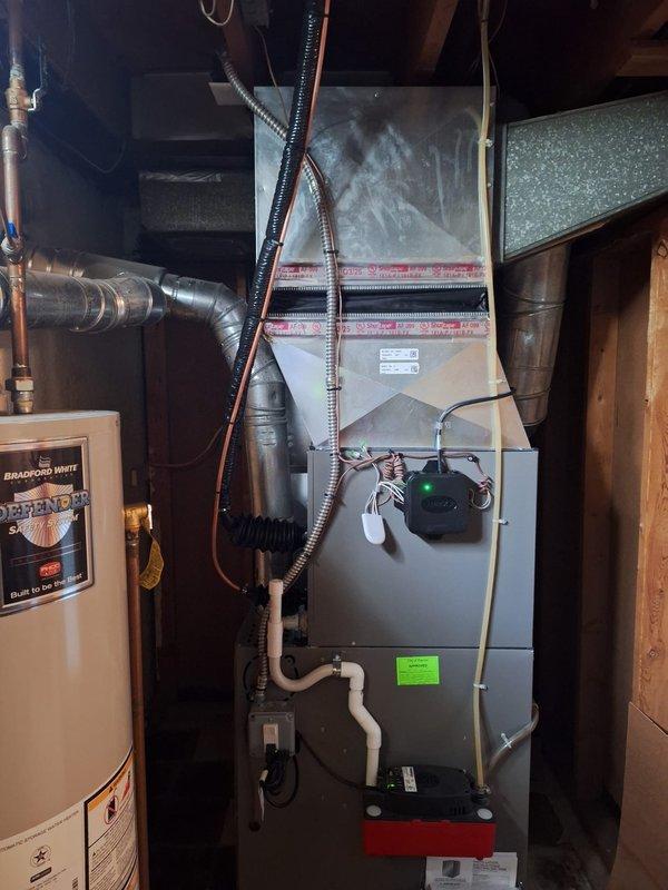 Completed installation of 2-ton air conditioning system with matching evaporator coil in residential basement location. Installed new air handler unit with R-454B refrigerant system, connected copper refrigerant lines, and integrated all ductwork connections to existing infrastructure. Set up condensate pump for proper drainage, completed all electrical connections, and verified system operation. Mechanical and electrical permits were obtained prior to installation, and all work was performed to code specifications with rear-positioned outdoor condenser unit reconnected to new indoor components.