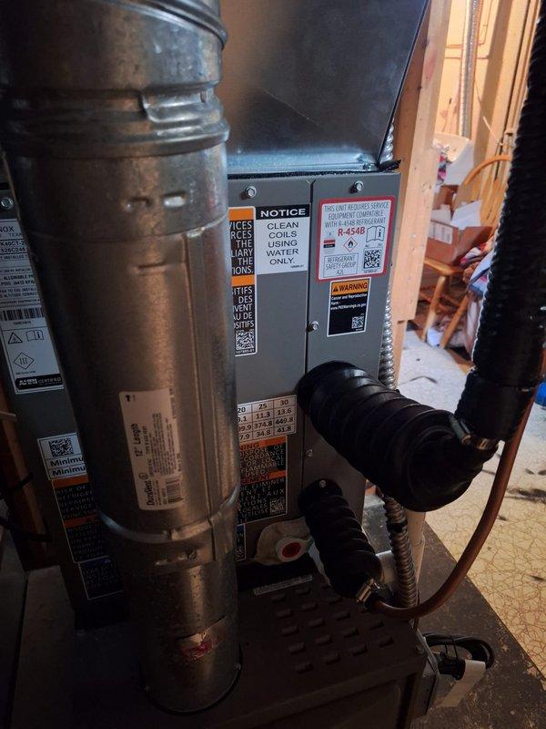 Completed installation of 2-ton air conditioning system with matching evaporator coil in residential basement location. Installed new air handler unit with R-454B refrigerant system, connected copper refrigerant lines, and integrated all ductwork connections to existing infrastructure. Set up condensate pump for proper drainage, completed all electrical connections, and verified system operation. Mechanical and electrical permits were obtained prior to installation, and all work was performed to code specifications with rear-positioned outdoor condenser unit reconnected to new indoor components.