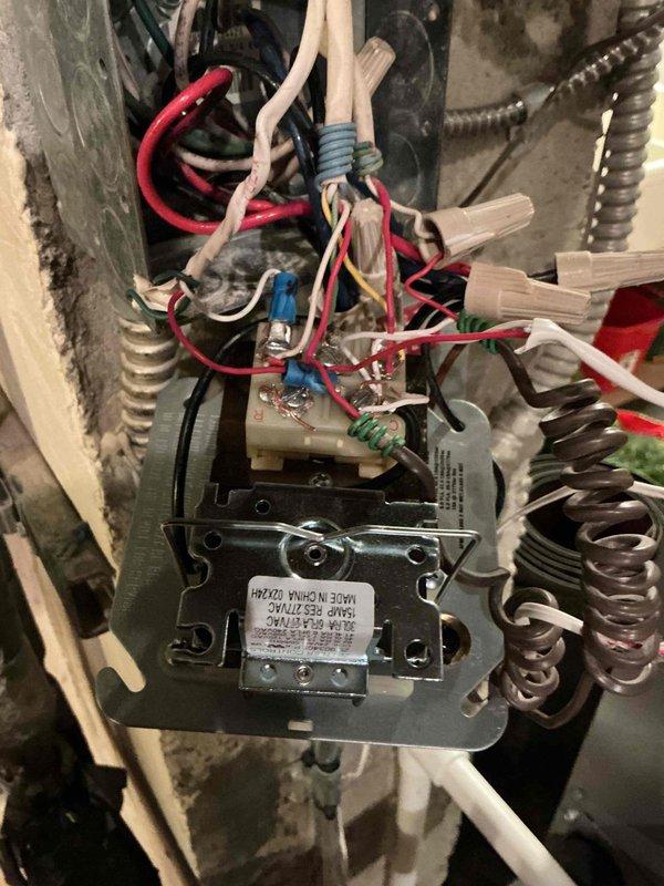 Responded to no cooling call for 3-year-old air handler system located in basement. Upon arrival, confirmed neither the air handler blower nor outdoor condensing unit were operating, though power was present at the equipment. Performed diagnostic evaluation of electrical control system and humidifier integration. Inspected control relay/transformer assembly and associated wiring connections within air handler control compartment. Examined capacitor previously replaced one year prior. Documented existing electrical configuration including humidifier control wiring, relay connections, and power distribution components for system troubleshooting and repair recommendations.