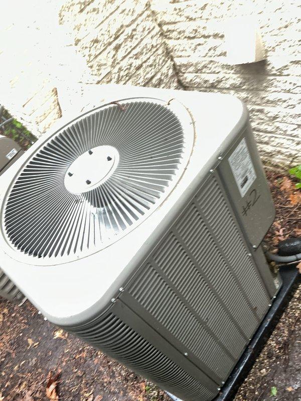 Completed Gold AC inspection on residential property with two Lennox air conditioning systems, both approximately 2 years old. Performed comprehensive multi-point inspection on both outdoor condenser units, checking refrigerant levels, electrical connections, compressor operation, and fan motor performance. Inspected indoor air handler located in basement, verifying proper airflow, drain line functionality, and thermostat operation. Both systems operating within normal parameters with no immediate service needs identified. Documented equipment condition with photographs showing minor accumulation of outdoor debris around condenser units, which is typical for exterior installations. Confirmed with homeowner that both units are functioning properly prior to inspection. All safety controls tested and verified operational on both systems.