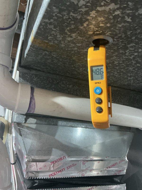 Responded to callback for AC unit not cooling below 72°F approximately 1-1.5 weeks after recent maintenance visit. Upon inspection, found outdoor condenser coil heavily contaminated with dirt, dust, debris, and organic growth including algae/mold accumulation on fins and grille surfaces, significantly restricting airflow and heat transfer capability. Measured supply air temperature at 48.6°F at ductwork, confirming refrigerant circuit operational but system operating at reduced capacity due to fouled condenser. Cleaned condenser coil thoroughly to restore proper airflow and heat rejection, verified system operation and cooling performance restored to manufacturer specifications.
