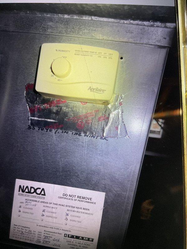 Completed comprehensive Gold AC inspection on 3-year-old single-unit Lennox system with basement-located air handler. Performed full multi-point inspection of outdoor condenser unit positioned on concrete pad with proper clearance and landscaping rock surround, verified operational status of all components including fan motor and coil assembly. Inspected indoor air handler equipped with Aprilaire humidistat control, confirmed proper airflow, checked electrical connections, verified refrigerant levels, cleaned condenser coils, and documented system performance with NADCA certification label present indicating previous maintenance compliance. All equipment found operating within normal parameters with no immediate service needs identified.