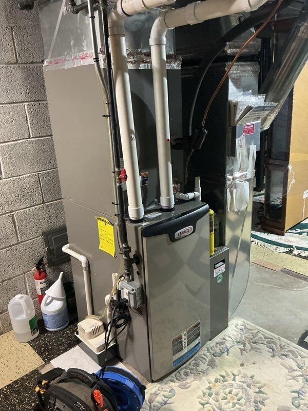 Responded to service call for air conditioning system requiring refrigerant recharge and leak repair. Upon arrival, located 10-year-old Lennox system with evaporator coil installed in basement mechanical room. Performed comprehensive leak search using electronic detection equipment and pressure testing methods on refrigerant lines and service connections. Connected manifold gauges to service ports to assess system pressures and confirm refrigerant loss. Inspected all accessible refrigerant lines, coil connections, and brass service valves for signs of leakage. Documentation photos captured equipment setup, gauge readings, and service port connections during diagnostic procedures. System evaluation completed to determine extent of refrigerant loss and identify leak source prior to repair recommendations.