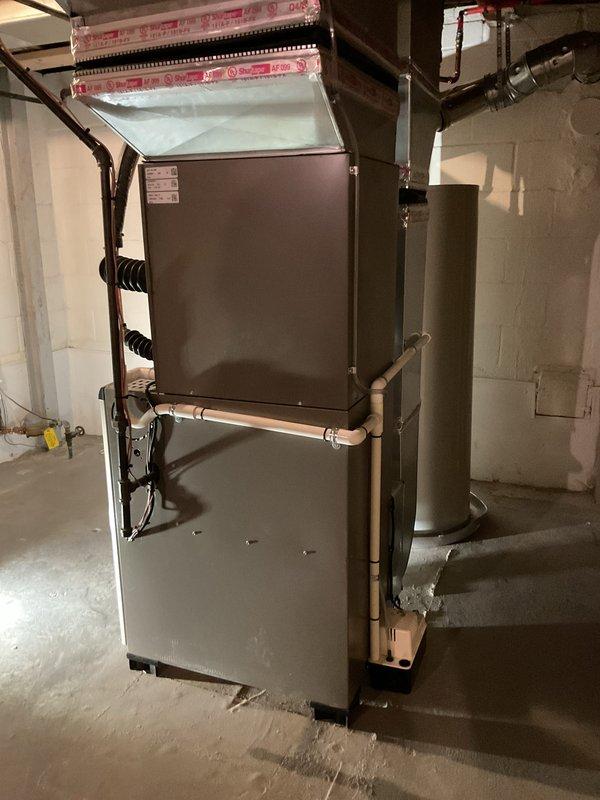 Completed full HVAC system installation including 90,000 BTU high-efficiency furnace, 2.5-ton air conditioning unit, programmable thermostat, and humidifier in unfinished basement location. Installed new metallic ductwork with insulation wrapping, connected copper refrigerant lines, and ran PVC venting for condensate drainage. Mounted furnace on concrete floor against block wall foundation with proper clearances. Ran black electrical conduit and wiring for power connections. Installed supply and return air plenums with pink foam insulation board. Connected all ductwork to existing trunk lines with 600 CFM airflow capacity. Installed condensate pump for drainage management and performed system flush. Reconnected existing electrical circuits as required. Verified proper refrigerant charge and system pressures. Tested all safety controls, ignition sequence, and airflow distribution. System startup completed with all equipment operating within manufacturer specifications. Mechanical and el