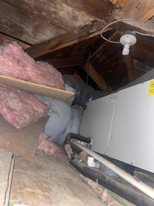 Conducted on-site assessment of existing standalone air conditioning system in preparation for replacement estimate. Inspected attic-mounted air handler unit and associated refrigerant lines, documenting current equipment condition and installation configuration. Photographed existing HVAC components including air handler, refrigerant piping, and ductwork to support replacement proposal for system independent of existing steam boiler heating infrastructure.