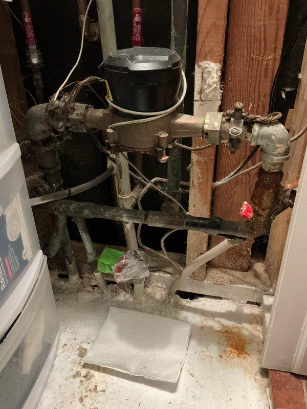 Responded to emergency call for broken copper water line where exterior pipe penetrates brick wall foundation and enters the building. Upon arrival, found interior wall already opened providing direct access to damaged section. Replaced compromised copper piping segment at wall penetration point, installed new fittings and connections, and pressure tested entire system to verify integrity. Confirmed all shut-off valves operational and no additional leaks present in surrounding plumbing assembly.