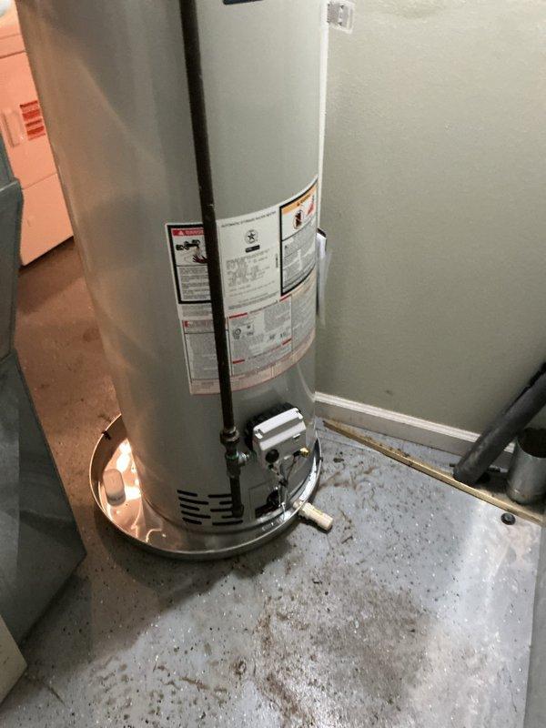 Completed installation of a 40-gallon standard capacity tanked water heater in the mechanical utility space. Positioned unit on existing white concrete platform with drip pan for secondary containment and leak protection. Reconnected all necessary plumbing lines, installed pressure relief valve with proper discharge piping, and verified all connections for code compliance. Ensured proper venting through black exhaust pipe and confirmed all manufacturer specifications were met. All water supply connections were secured and tested for leaks. Unit is fully operational and ready for service.