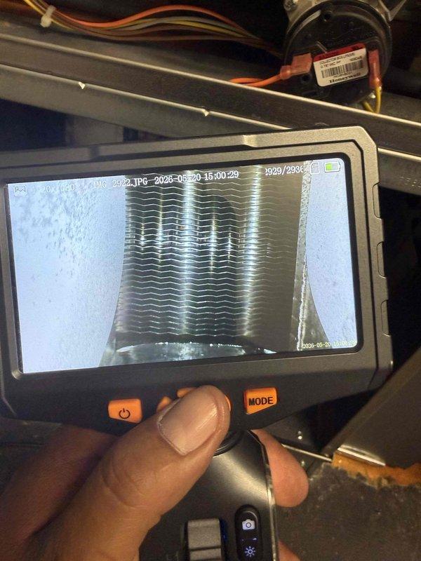 Completed comprehensive tune-up and inspection on 10-year-old HVAC system located in basement, including CO2 level assessment as requested. Performed visual inspection of outdoor condenser unit, noting accumulated debris between fins and heat exchanger slats requiring attention. Utilized borescope camera to conduct internal inspection of evaporator coil assembly, documenting condition of fins and heat exchanger components for maintenance records.