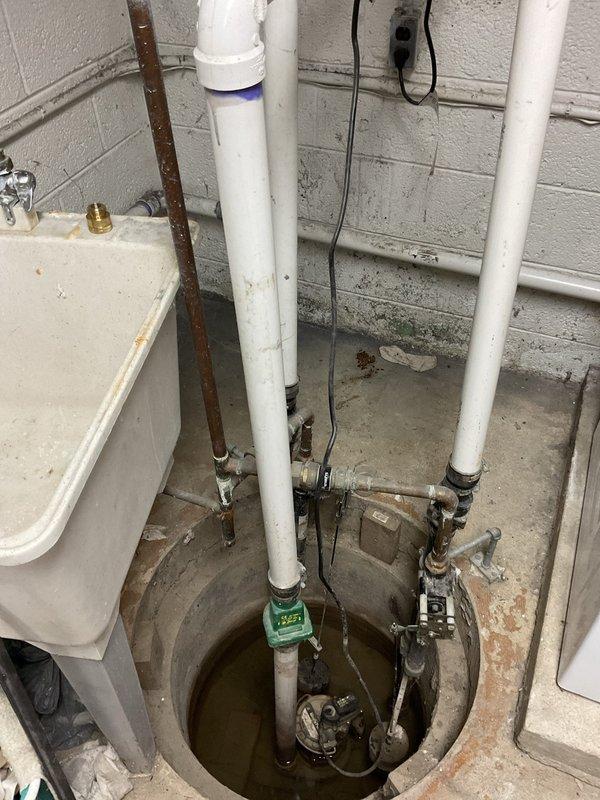Responded to a plumbing service call at a 76-year-old residential property requiring water pipe capping in the basement. Upon arrival, inspected the basement utility area containing a sump pump pit system with multiple exposed PVC and metal pipes that had been left uncapped for an extended period. The work area included white PVC drainage lines, rusted metal piping, and various plumbing connections around the sump pit with visible water damage and moisture staining on surrounding surfaces.

Successfully capped all exposed water pipes in the basement to prevent water flow and potential flooding. Work focused on securing open pipe ends with appropriate caps and fittings to ensure proper water shutoff. The installation addressed immediate concerns related to the uncapped pipes that posed risks of water damage and system inefficiency. All capping work was completed using industry-standard materials compatible with the existing PVC and metal pipe infrastructure present in the 1950s-era home