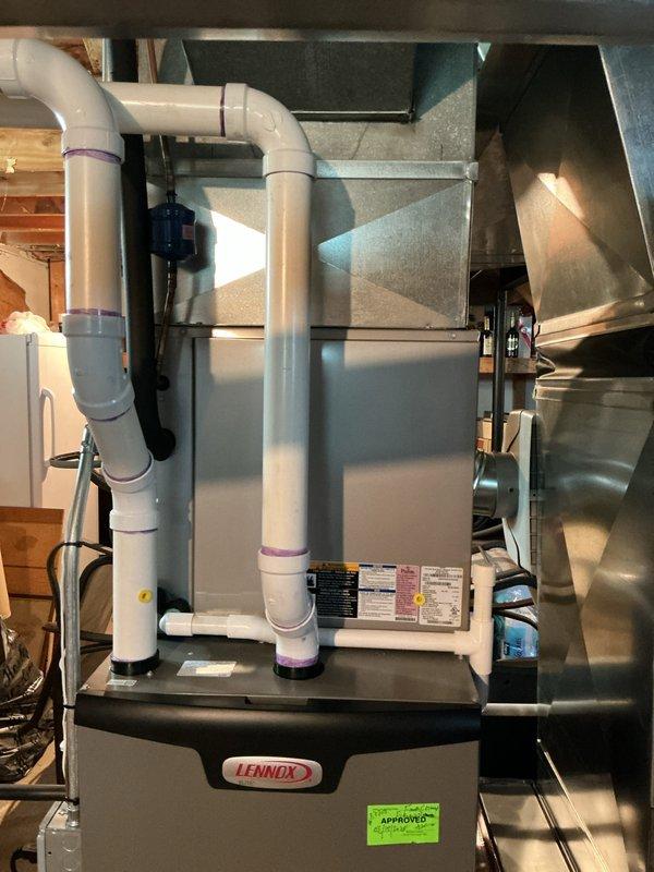 Conducted comprehensive evaluation of 14-year-old residential air conditioning system experiencing multiple failure indicators. Identified active refrigerant leak, severely pitted contactor showing signs of electrical arcing, and compressor exhibiting abnormal noise during startup and shutdown cycles indicating internal mechanical wear. Documented existing Lennox air handler installation in basement with associated ductwork and drainage systems. Prepared replacement estimate for complete HVAC system upgrade, noting that outdoor condenser pad area requires clearance of debris and animal waste prior to installation. Verified current system operational status and photographed equipment configuration including furnace, air handler, ductwork connections, and PVC condensate drainage lines for replacement planning purposes.