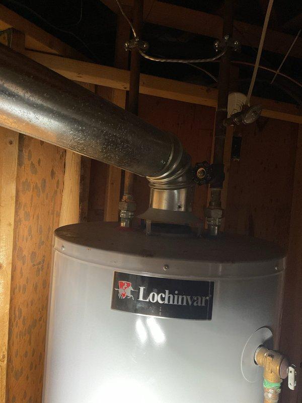 Responded to service call for Lochinvar water heater failing to ignite after three attempted starts. Inspected unit installed in basement utility area and verified all gas supply connections, venting system, and electrical components. Examined exhaust piping and flue configuration for proper operation. Additionally investigated reported water leak as flagged by water department. Conducted visual inspection of accessible plumbing throughout basement area, checking supply lines, drain connections, and fixtures for signs of moisture or active leaks. Photographed water heater installation and surrounding plumbing infrastructure for documentation purposes. Assessed copper and brass pipe fittings at water heater connections for potential leak sources.