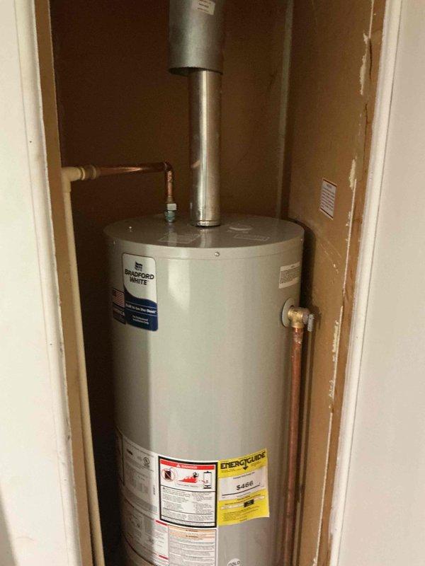Successfully installed a Bradford White tanked water heater in a mobile home utility closet with proper venting through vertical exhaust pipe. Connected copper supply lines and ensured all connections were secure and code-compliant for residential manufactured home application.