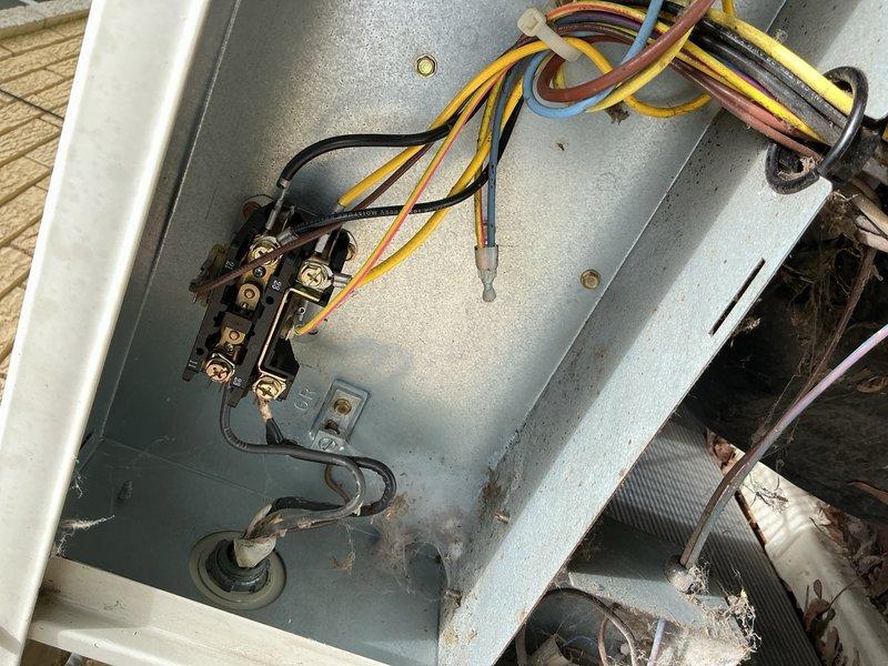 Completed comprehensive air conditioning inspection and tune-up on 20-year-old residential cooling system with outdoor condenser unit located in backyard on wooden deck and indoor components in basement. Performed full system evaluation including inspection of electrical connections at junction box, assessed condenser unit operation and heat exchanger condition, verified proper electrical supply at disconnect box, and documented equipment condition with focus on aging components showing weathering and oxidation on exterior panels and electrical housing. All accessible components inspected and system operational at time of service completion.