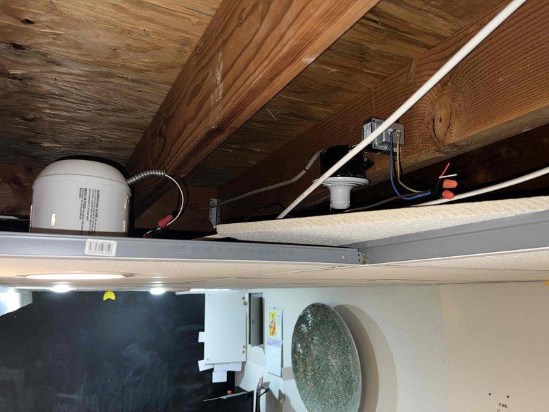 Responded to service call for thermostat not activating air conditioning system while furnace operation remained functional. Upon inspection, found thermostat wiring configuration with multiple conductors present including Y1, Y2, G, OB, RC, W1, W2 AUX, C, and Rh terminals. Verified proper wire connections at thermostat base plate and traced wiring through attic space to air handler location. Identified cooling call circuit issue preventing compressor engagement. Corrected wiring connections at thermostat terminal block to restore proper communication between thermostat and 10+ year old air conditioning unit. Tested system operation through complete cooling cycle to confirm proper compressor startup and verified furnace heating function remained intact. System now operating correctly in both heating and cooling modes.