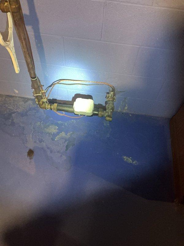 Responded to service call for leaking tanked water heater. Upon inspection, identified active leak originating from top connections of unit. Verified installation history showing two water heaters installed in 2018 with one previous warranty replacement already completed. Examined copper piping configuration with brass fittings and isolation valves connected to the affected unit. Documented current condition of plumbing assembly and leak source through photographic evidence. Assessed warranty status on both tanks to determine coverage eligibility for the leaking unit. Recommended appropriate repair or replacement action based on warranty verification and leak severity.