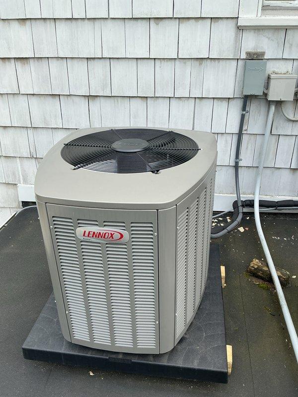 Completed comprehensive Gold AC Inspection and tune-up on a 3-year-old Lennox air conditioning system installed in 2017. Performed full preventive maintenance protocol on the outdoor condenser unit, including cleaning of condenser coils, inspection of refrigerant levels, electrical connections, and compressor operation. Verified proper airflow through louvered vents and confirmed fan motor functionality. Inspected electrical disconnect box and associated conduit for proper installation and safety compliance. Checked condensate drain line routing and verified unit stability on composite pad. System operating within normal parameters with no issues identified. Unit shows evidence of recent maintenance with protective materials in place, indicating ongoing care. Rooftop installation assessed for proper drainage and potential impact from organic growth on surrounding membrane surface, though unit remains unaffected. All components tested and confirmed operational for upcoming cooling seaso