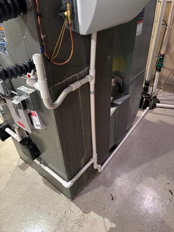 Completed installation of 4-ton air conditioning system with matching evaporator coil and whole-home humidifier in basement mechanical room. System configured as rear-discharge unit with refrigerant lines reconnected to outdoor condenser. All electrical and mechanical permits secured prior to installation, white PVC condensate drainage installed, and ductwork integration completed with existing furnace system to ensure proper airflow and humidity control throughout the residence.