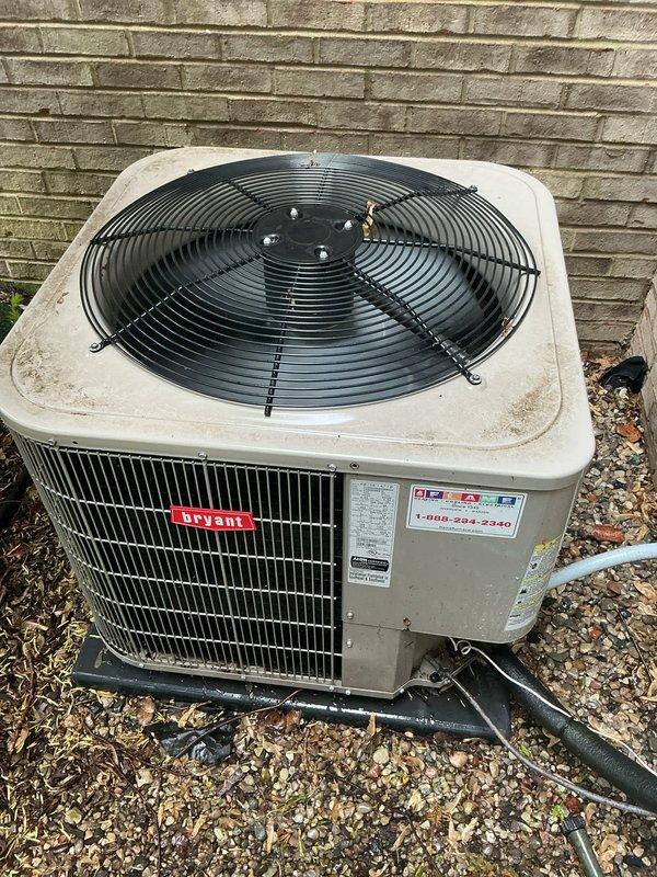 Completed comprehensive Gold AC inspection on 10+ year old Bryant air conditioning system. Performed thorough examination of outdoor condensing unit positioned on gravel pad against exterior brick wall, including visual assessment of cabinet condition, fan assembly, and refrigerant line connections. Inspected manufacturer labels and specifications, verified proper mounting and drainage around unit base. Evaluated indoor air handler and coil assembly located in basement. Confirmed system operational status with all components functioning as designed. Unit showing normal wear consistent with age, with minor surface weathering on exterior cabinet. Documented equipment condition through photographic records for maintenance history. All safety checks completed and system cleared for continued operation.