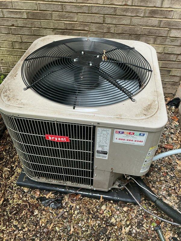 Completed comprehensive Gold AC inspection on 10+ year old Bryant air conditioning system. Performed thorough examination of outdoor condensing unit positioned on gravel pad against exterior brick wall, including visual assessment of cabinet condition, fan assembly, and refrigerant line connections. Inspected manufacturer labels and specifications, verified proper mounting and drainage around unit base. Evaluated indoor air handler and coil assembly located in basement. Confirmed system operational status with all components functioning as designed. Unit showing normal wear consistent with age, with minor surface weathering on exterior cabinet. Documented equipment condition through photographic records for maintenance history. All safety checks completed and system cleared for continued operation.