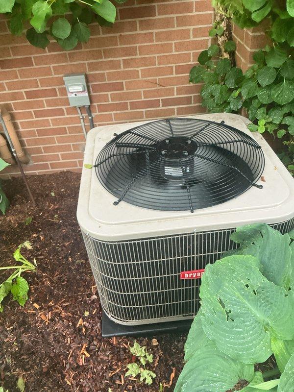 Completed comprehensive Gold AC inspection on 4-year-old residential air conditioning system with air handler located in basement. Performed thorough evaluation of outdoor condenser unit, including inspection of condenser coils, fan operation, refrigerant lines, and electrical disconnect. Verified proper clearance around unit, assessed landscaping proximity, and confirmed adequate airflow through condenser fins. Documented equipment condition through photographic records showing unit positioned on proper pad with appropriate mulch base and maintained surroundings. System found to be operational with no immediate service requirements identified during inspection.